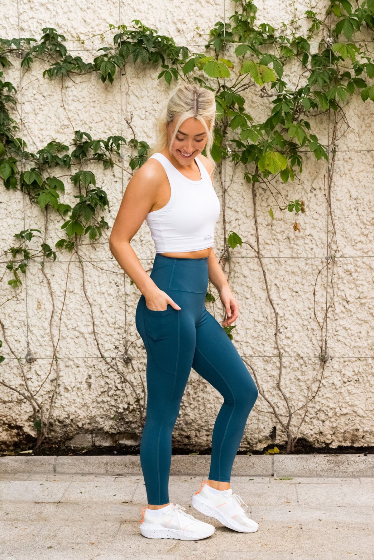 Woman wearing a compression legging. This sleek flattering legging is completely Squat proof, with an Ultra High Waistband with an adjustable flatline drawstring elastic.