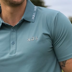 A golfer wearing a golf polo that was designed in a performance-stretch material with moisture managing properties for all day comfort.