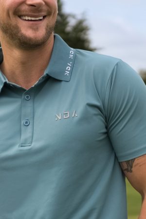 A golfer wearing a golf polo that was designed in a performance-stretch material with moisture managing properties for all day comfort.