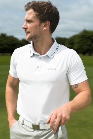 A golfer wearing a golf polo that was designed in a performance-stretch material with moisture managing properties for all day comfort.