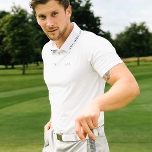 A golfer wearing a golf polo that was designed in a performance-stretch material with moisture managing properties for all day comfort.