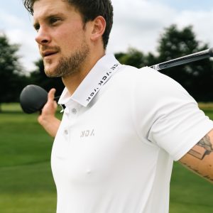 A golfer wearing a golf polo that was designed in a performance-stretch material with moisture managing properties for all day comfort.