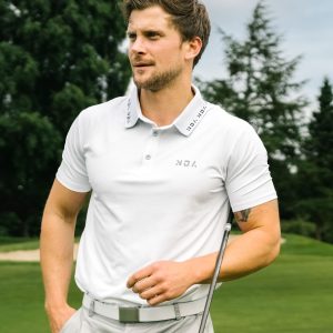 A golfer wearing a golf polo that was designed in a performance-stretch material with moisture managing properties for all day comfort.