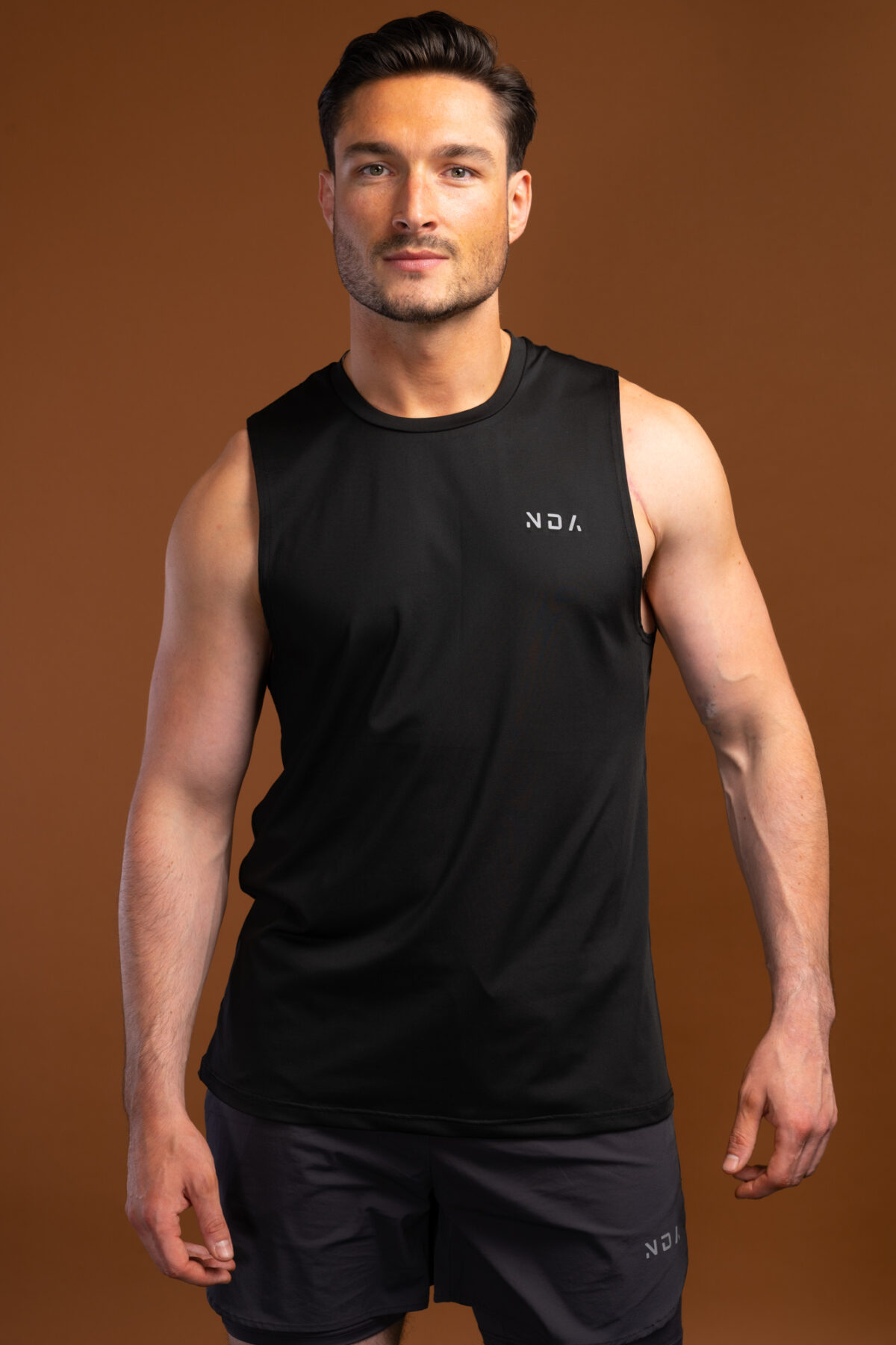 The Tempo Tank Top (Black) is a must-have for any active man who wants to stay cool and comfortable during his workouts. The lightweight compression material is designed to keep you cool and dry, while the vented sides provide extra breathability. The no-sleeve design allows you to move freely without feeling restricted. Get ready to take your workouts to the next level.