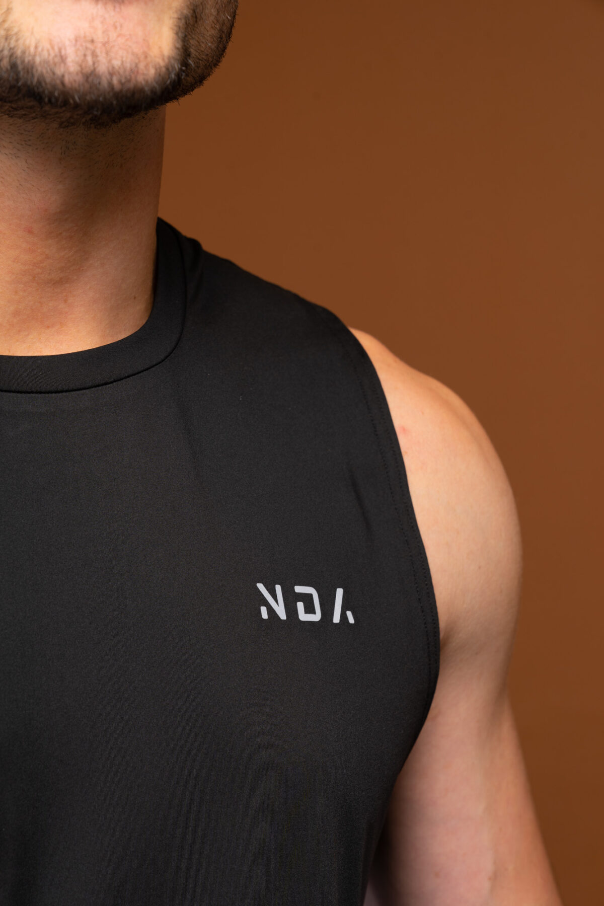 The Tempo Tank Top (Black) is a must-have for any active man who wants to stay cool and comfortable during his workouts. The lightweight compression material is designed to keep you cool and dry, while the vented sides provide extra breathability. The no-sleeve design allows you to move freely without feeling restricted. Get ready to take your workouts to the next level.