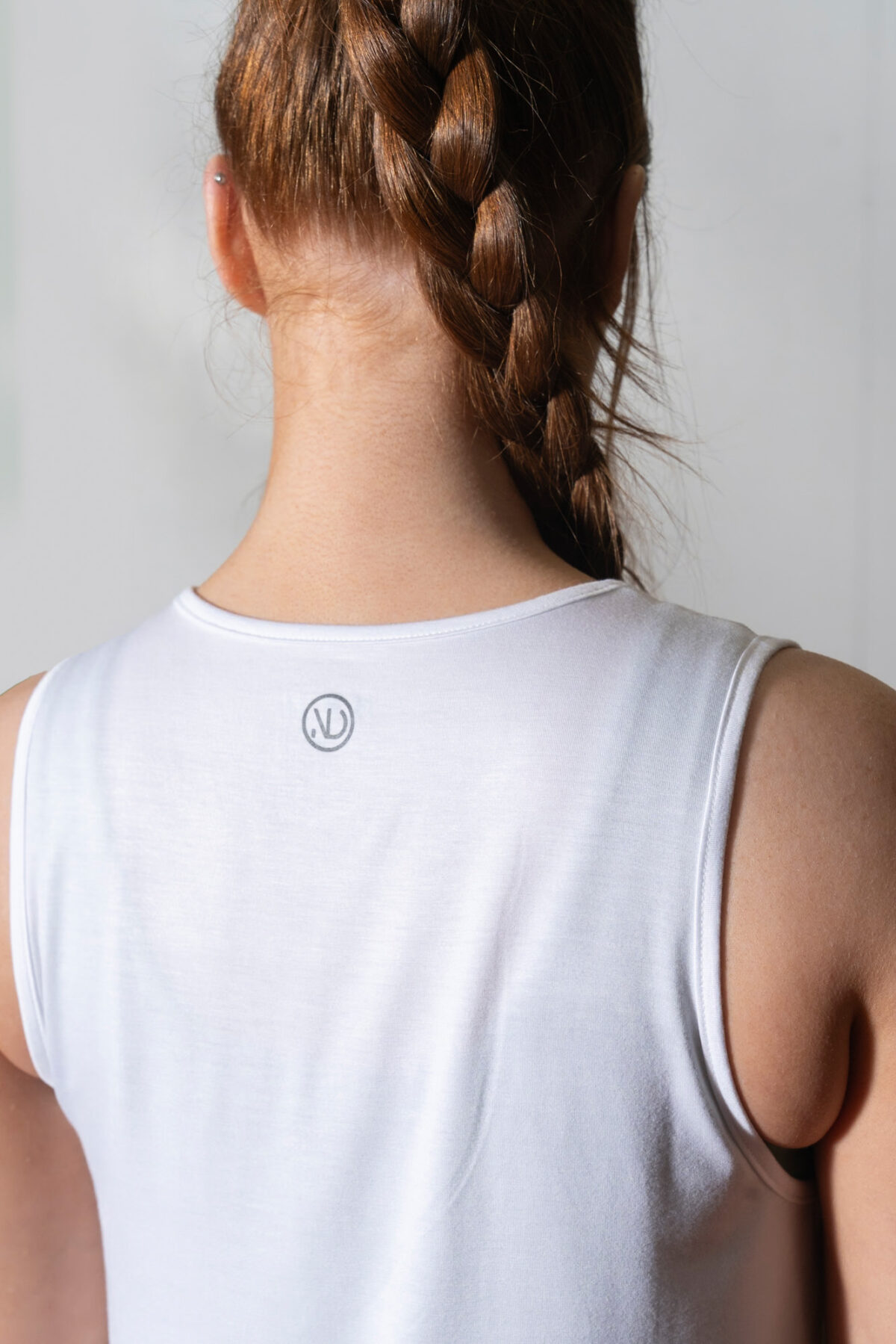 Elevate Vest Top (White). Made from moisture-wicking fabric, this lightweight and breathable top offers maximum movement and flexibility.