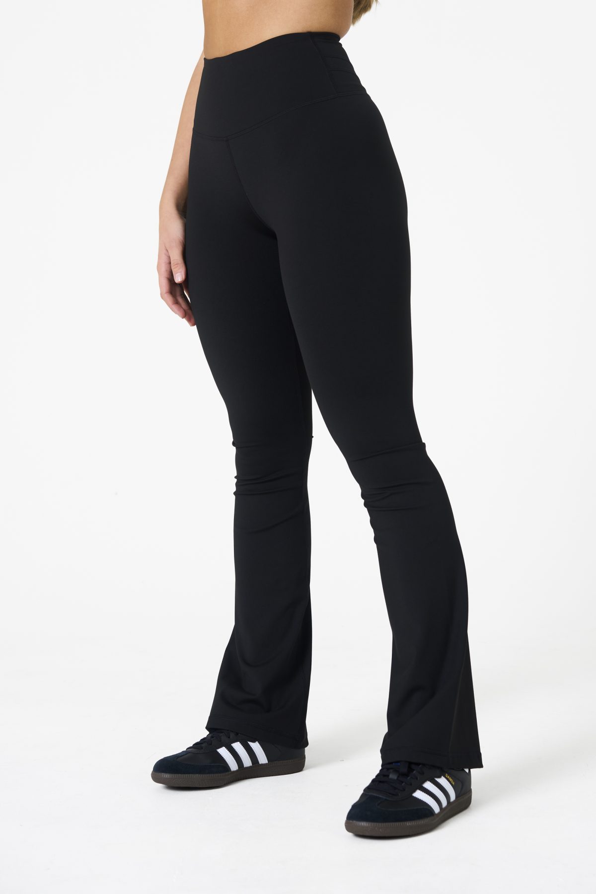 Move freely and confidently with the Legacy Flare Legging (Black), designed for comfort, support, and style. Part of our Legacy Activewear Collection, this legging combines innovative features with a modern flair to elevate your active wardrobe. The high-waisted design ensures a secure fit, while the flatline drawstring offers customizable support for every movement. The subtle back-enhanced detail adds a sculpted, flattering touch. The flare silhouette delivers a trendy yet functional look, giving you ease of movement whether you're in the gym or out and about.