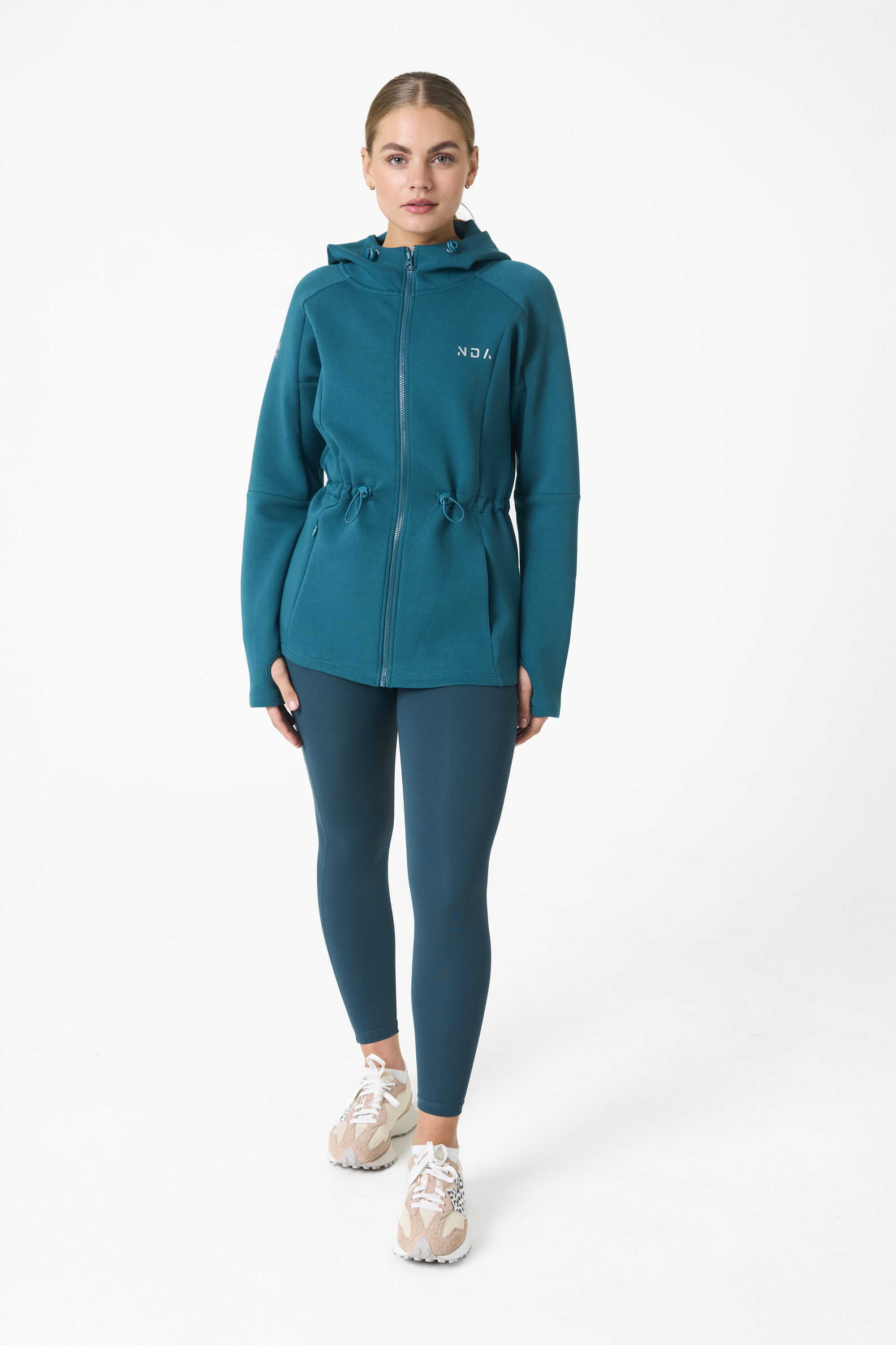 Elevate your activewear game with the Legacy Zip Hoodie (Dark Teal) from our Legacy Activewear Collection. Designed for ultimate movement, support, and comfort, this hoodie seamlessly blends practicality with style. The full-zip closure offers effortless wearability, while the adjustable hood and elasticated waist ensure a personalized fit. Perfect for your on-the-go lifestyle, it features two convenient pockets: a secure zipped pocket for essentials and a classic open pocket for quick access. The Legacy Zip Hoodie is your go-to for both functionality and trend-forward fashion.