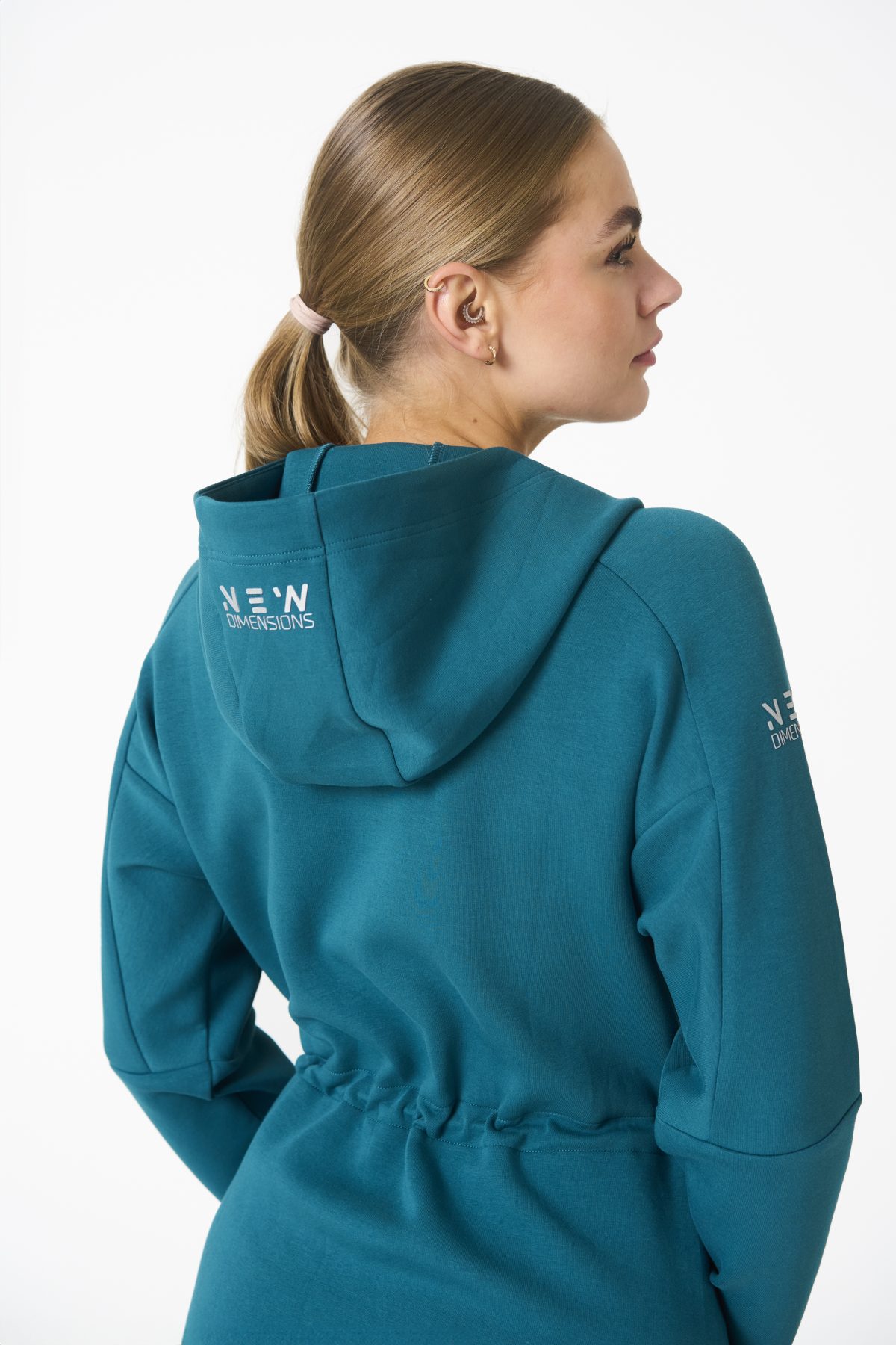 Elevate your activewear game with the Legacy Zip Hoodie (Dark Teal) from our Legacy Activewear Collection. Designed for ultimate movement, support, and comfort, this hoodie seamlessly blends practicality with style. The full-zip closure offers effortless wearability, while the adjustable hood and elasticated waist ensure a personalized fit. Perfect for your on-the-go lifestyle, it features two convenient pockets: a secure zipped pocket for essentials and a classic open pocket for quick access. The Legacy Zip Hoodie is your go-to for both functionality and trend-forward fashion.